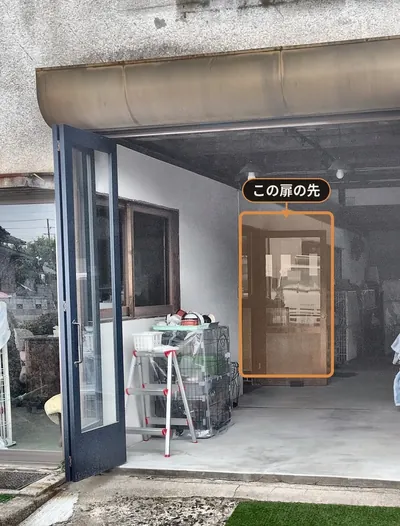 倉庫シャッターに向かって左手にある、流しのある部屋の扉